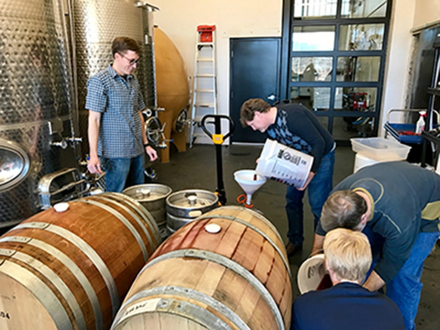 Students learning commercial winemaking techniques in a professional winery